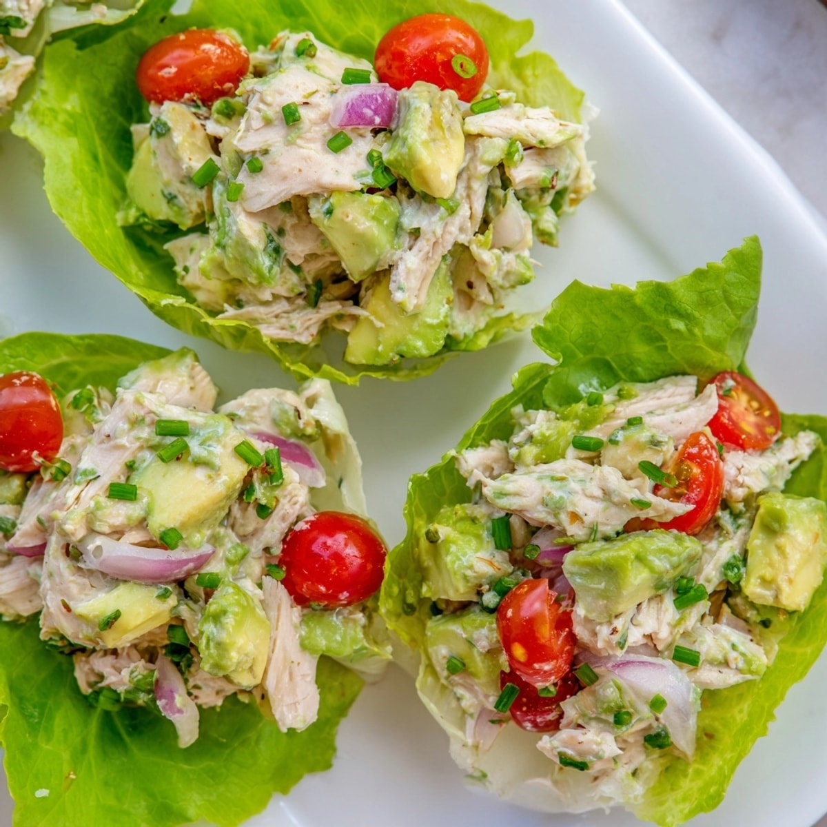 Creamy Avocado Ranch Chicken Salad Cups, nestled inside delicate butter lettuce leaves, a quick lunch.