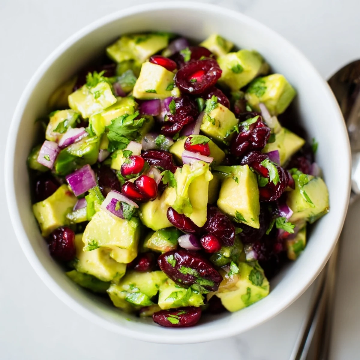 Cranberry Jalapeño Avocado Salsa served with crispy tortilla chips and fresh lime.  