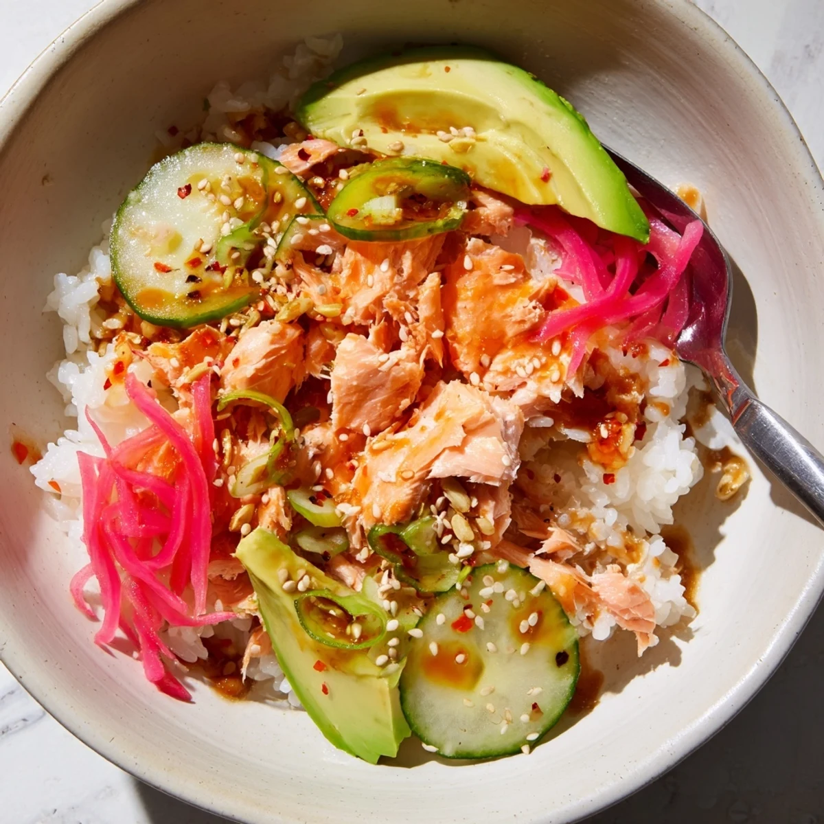 Delicious Leftover Salmon & Rice Bowl topped with fresh avocado and cucumber slices.  
