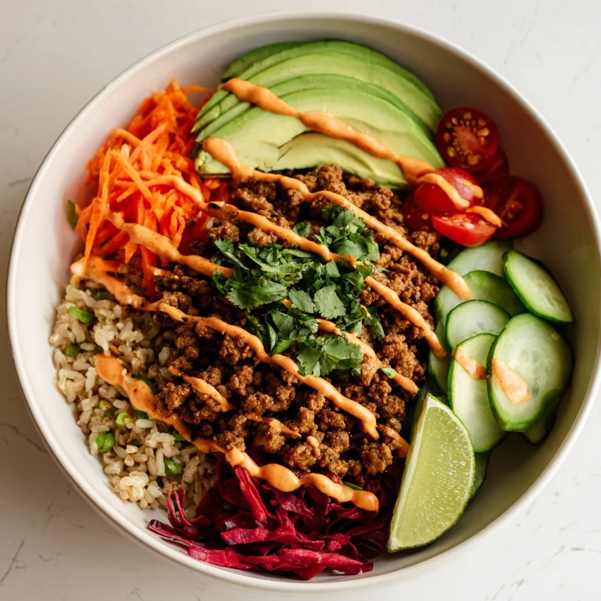 A colorful plant-based meat bowl topped with fresh veggies and zesty lime.  