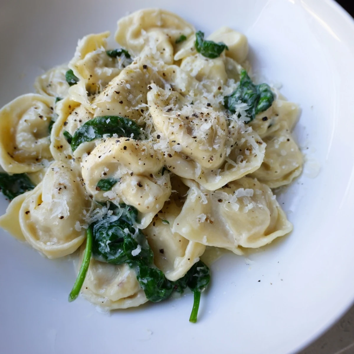 Enjoy a warm bowl of creamy Spinach Alfredo Tortellini, ready in 30 minutes, featuring fresh spinach.