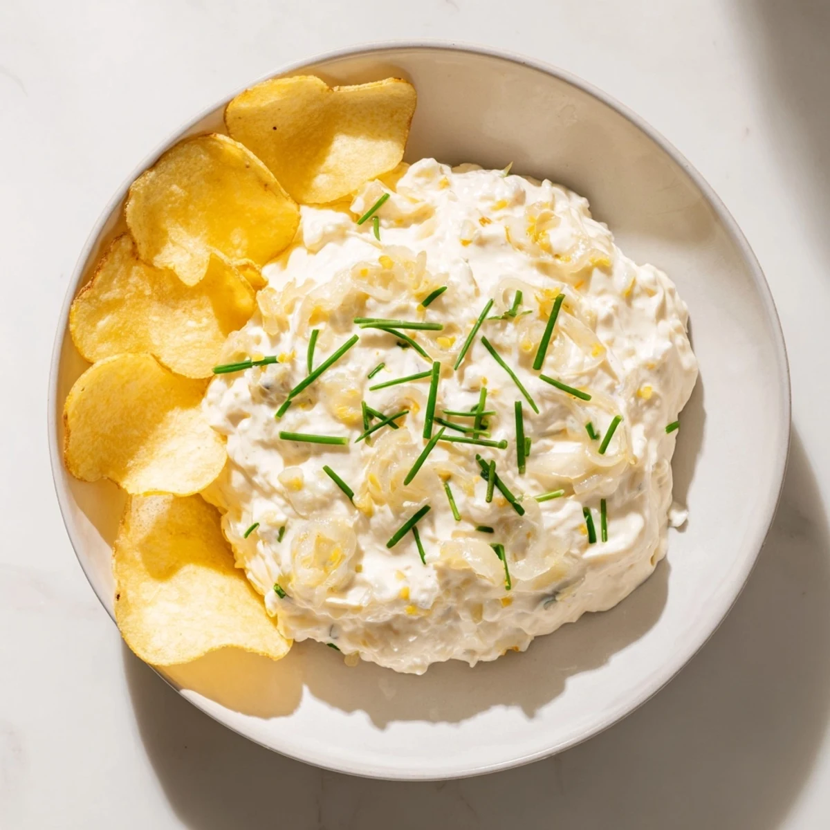 Golden potato chips ready to be dipped into the homemade onion dip for delicious snacking.
