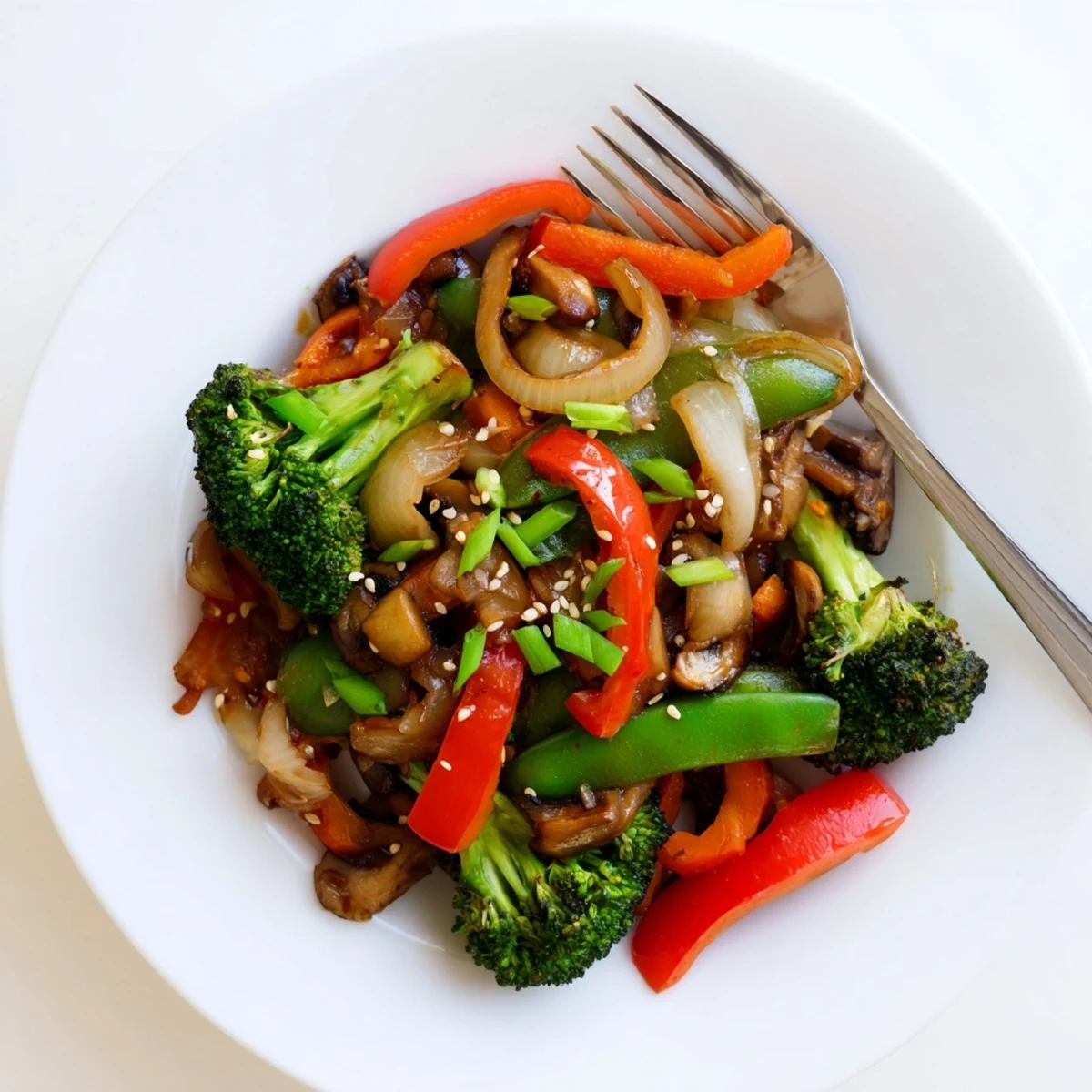 Tossing broccoli, carrots, and snap peas with aromatic ginger and garlic in a hot skillet for a quick, healthy vegan dinner.