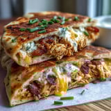 A close-up of Ranch Crack Chicken Stuffed Naan served with fresh chives and ranch dressing for dipping.
