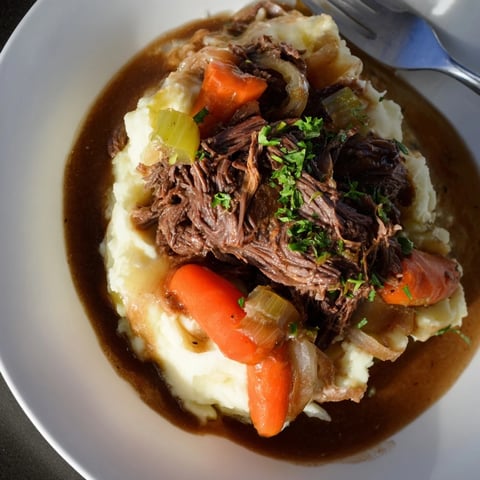 Slow Cooker Pot Roast with Mashed Potatoes served warm and drizzled with rich gravy.  