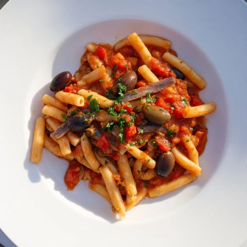 Steaming Puttanesca Ditalini, a flavorful Italian pasta dish with olives and capers, ready to be enjoyed.