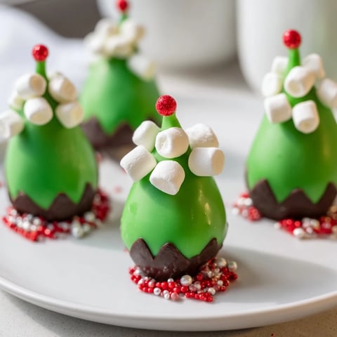 Festive elf hat chocolate dipped strawberries, a fun holiday dessert with vibrant green and white chocolate.