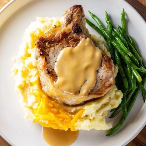 A comforting Pork Chops & Cheddar Mash Bowl, featuring tender pork atop creamy mashed potatoes.