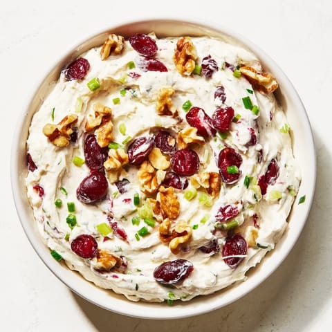 A close-up of a delightful holiday spread: lightened cream cheese dip garnished with fresh cranberries.
