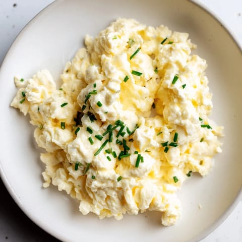Creamy Cottage Cheese Scrambled Eggs, cooked to perfection, garnished with fresh herbs.