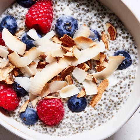 A close-up of chilled Poppy Seed Chia Pudding showing its thick, gelatinous texture with poppy seeds and almond toppings.