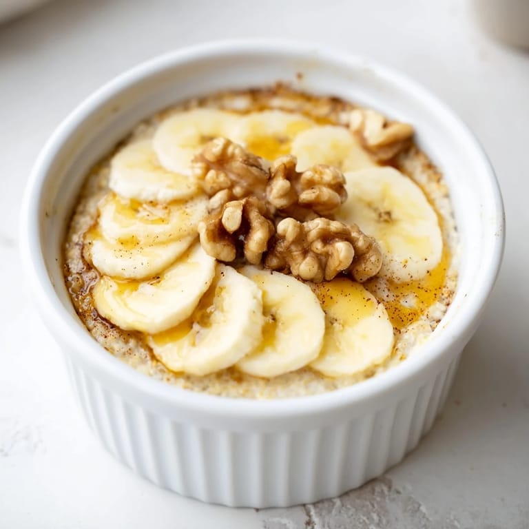 Perfectly baked oats ramekins with a crispy top, highlighting the warm oats with bananas.