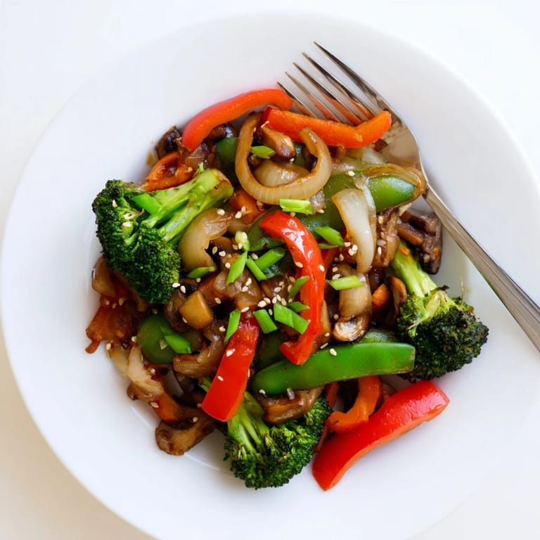 Tossing broccoli, carrots, and snap peas with aromatic ginger and garlic in a hot skillet for a quick, healthy vegan dinner.
