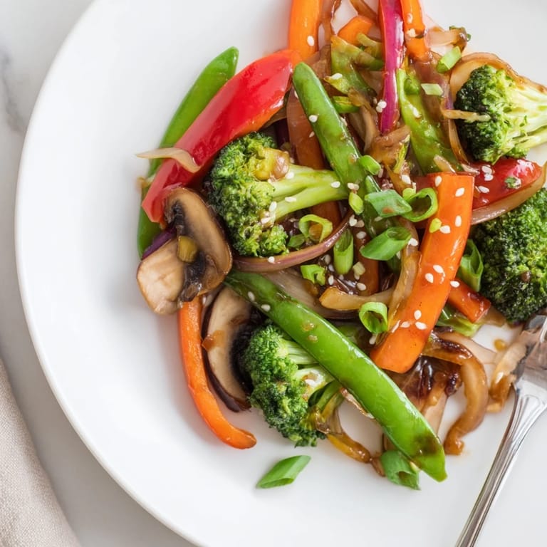 Ginger stir-fried vegetables topped with toasted sesame seeds and green onions, a colorful, crunchy Asian-inspired meal for busy weeknights.