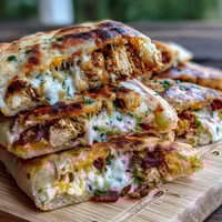 Golden grilled Ranch Crack Chicken Stuffed Naan with melted cheddar and bacon bits on a plate.